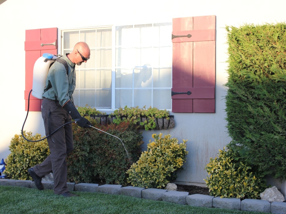 a man with a vacuum in front of a house